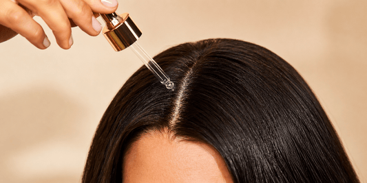 Luxury close-up of hair oil being applied to a healthy scalp with a dropper for deep nourishment and scalp care.