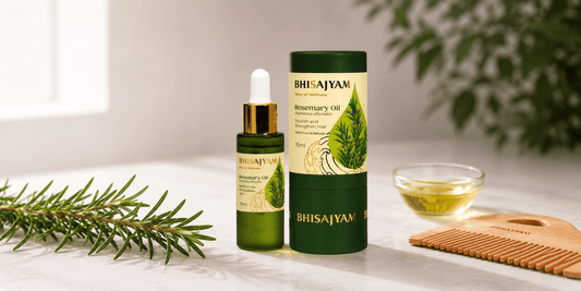 Bhisajyam Rosemary Oil bottle and packaging displayed with fresh rosemary sprigs, a wooden comb, and a bowl of oil on a marble surface in a natural wellness-inspired setting