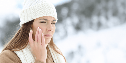 Woman dressed warmly in winter clothing outdoors in a snowy setting, representing winter care and seasonal wellness.
